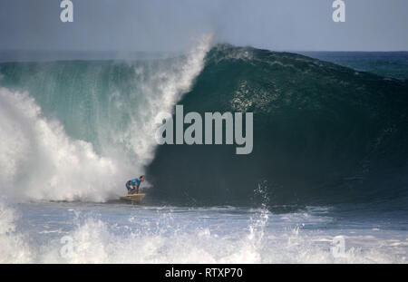 Surfer reitet eine große Welle, Waimea Bay, nördlich von Oahu, Hawaii, USA Stockfoto