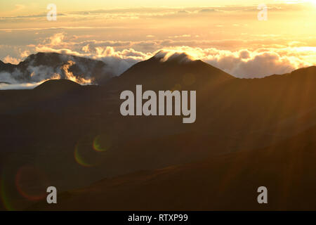 Wolken über einem Berg Rand auf dem Gipfel des Haleakala Vulkan bei Sonnenaufgang, Maui, Hawaii, USA Stockfoto