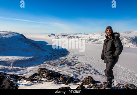 Wanderer steht auf dem Gipfel des Berges Duval und können sehen, die Stadt Pangnirtung, wo er begann. Stockfoto