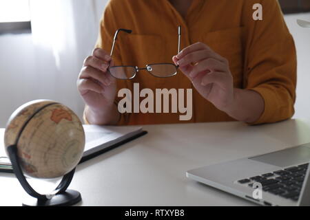 In der Nähe der weiblichen in legere Kleidung arbeiten und halten Gläser in Ihrem Büro Stockfoto