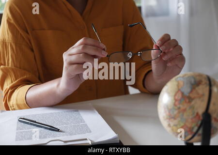 In der Nähe der weiblichen in legere Kleidung arbeiten und halten Gläser in Ihrem Büro Stockfoto