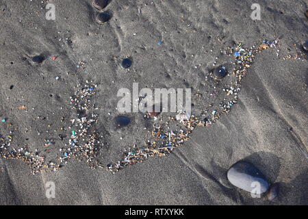 Kleine Kunststoffteile und microplastics in den sand Strand von Famara, Lanzarote, Spanien. Stockfoto