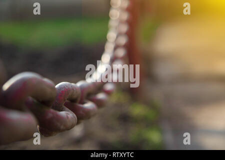 Close-up Alte Metall Kette auf Zaun Hintergrund im Sonnenlicht. Stockfoto