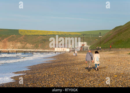 Paar wandern entlang der Kiesstrand in Saltburn-by-the-Sea, North Yorkshire, England. Stockfoto