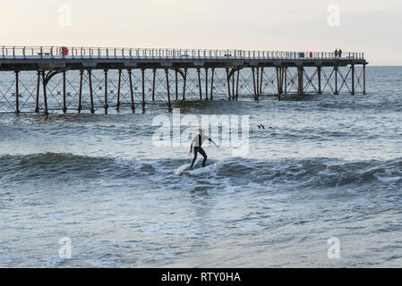 Surfer von der Pier in Saltburn-by-the-Sea, North Yorkshire, England. Stockfoto