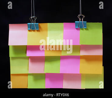 Bunte Aufkleber hängen an Clips, -, in der Nähe der dunkle Hintergrund Stockfoto