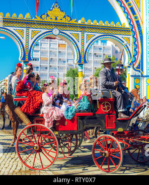 Spanische Familien in traditionellen und farbenfrohen Kleid in einem Pferd reisen Kutschen im April Messe, Stockfoto