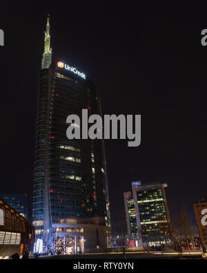 03/02/2019 Mialn, Italien: Unicredit Turm, Gae Aulenti Square, dem Finanzviertel von Mailand aus den neuen Park gesehen, die Bäume Bibliothek. Nächtliche Szene Stockfoto