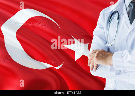 Türkische Arzt stehend mit Stethoskop auf die Türkei Flagge Hintergrund. Die nationalen Gesundheitswesen Konzept, medizinische Thema. Stockfoto