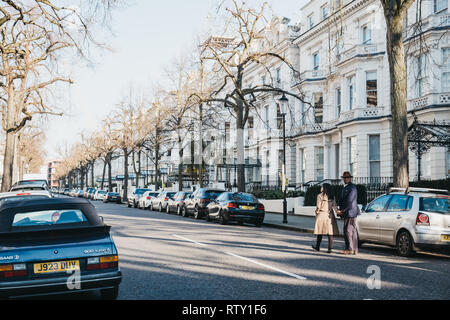 London, UK, 23. Februar 2019: Menschen zu Fuß auf einer Straße in Holland Park, die Royal Borough von Kensington und Chelsea, an einem sonnigen Frühlingstag. Hollan Stockfoto