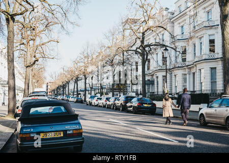 London, UK, 23. Februar 2019: Menschen zu Fuß auf einer Straße in Holland Park, die Royal Borough von Kensington und Chelsea, an einem sonnigen Frühlingstag. Hollan Stockfoto