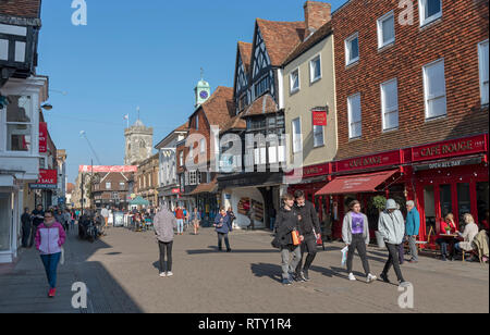 High Street, Salisbury, Wiltshire, England UK. Februar 2019. Käufer an der High Street in der Nähe der Eingang zum alten George Mall. Kirche Turm von St. Stockfoto