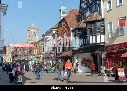 High Street, Salisbury, Wiltshire, England UK. Februar 2019. Käufer an der High Street in der Nähe der Eingang zum alten George Mall. Kirche Turm von St. Stockfoto