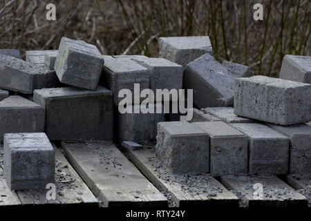 Alte Zement Blöcke auf einer Baustelle in Deutschland, Betonsteine auf ein verrottetes Holz- Palette in der Baustelle Bereich gestapelt Stockfoto