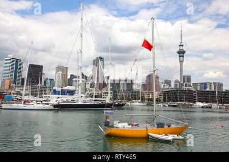Blick auf die Stadt von Auckland, mit hohen Anstieg skyscrappers im Hintergrund und einem gelben Segelboot in den Vordergrund, North Island, Neuseeland. Stockfoto
