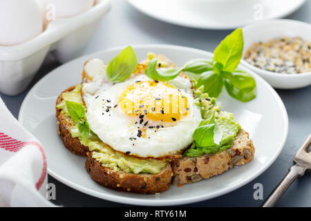 Avocado Toast mit gebratenen sunny side up Ei Stockfoto