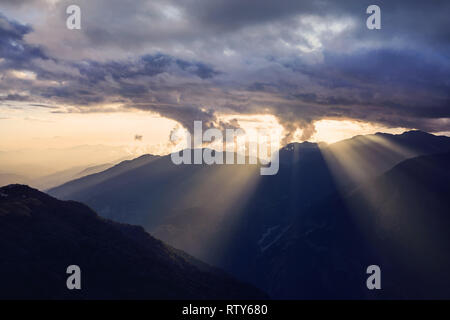 Schöne Sunett mit dramatischen Wolken und Sonnenstrahlen über die Hügel im Himalaya in Nepal Stockfoto