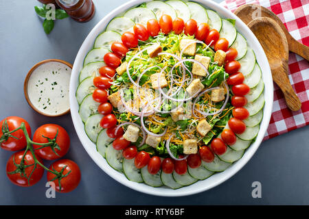 Haus Salat mit Zwiebeln, Croutons, Tomaten und Gurken Stockfoto