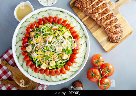 Haus Salat mit Zwiebeln, Croutons, Tomaten und Gurken Stockfoto