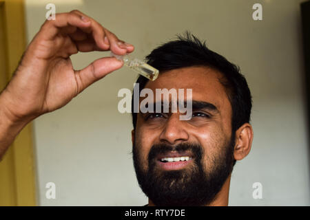 Junger Mann entomologe Beobachtung Insekten in Glas vile und versuchen, es für seine Insekt Probenentnahme während einer hellen Sommer zu identifizieren. Stockfoto