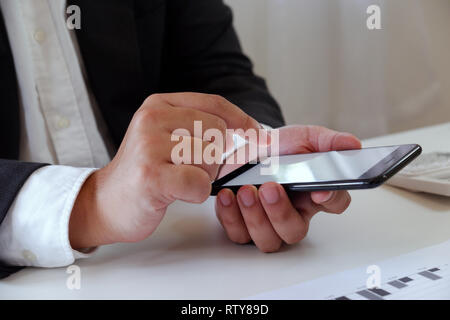 Unternehmer arbeiten im Büro mit Handy auf dem Schreibtisch Stockfoto