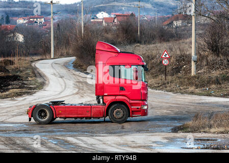 Red Semi Truck auf einer schmutzigen ländlichen Country Road Kreuzung Stockfoto