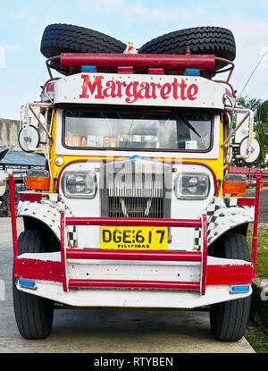 Santa Fe, Provinz Romblon, Philippinen - 12. März 2018: Nahaufnahme einer bunten alten Jeepney, mit zwei Ersatzreifen auf der Oberseite, Parkplatz auf der Straße Stockfoto