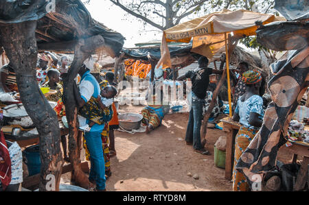 Ein schönes buntes Foto der Markt des geschäftigen Bauern im Kongo Dorf, Northern Ghana. Eine Frau in der Mitte ist Singen und Klatschen. Stockfoto