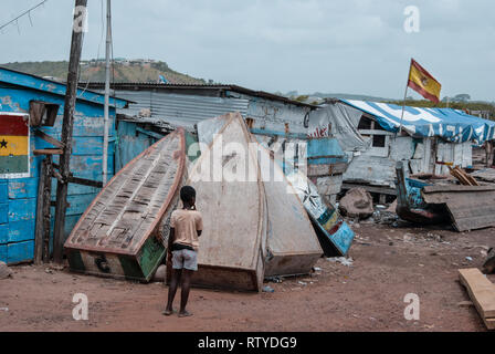 Ein schönes buntes Foto eines jungen Blick auf die alte hölzerne Fischerboote am Hafen in Elmina, Ghana, Westafrika Stockfoto