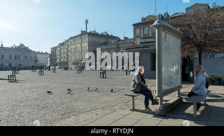 Menschen studieren einer Karte bei dem Metall Stühle im Speicher des jüdischen Volkes auf das Ghetto Heldenplatz, Krakau, Polen getötet Stockfoto