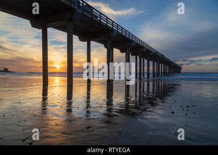 Sonnenuntergang am Scripps Pier und La Jolla Shores Beach vom Strand mit Sonne im Sand reflektiert. La Jolla, San Diego, Kalifornien, USA Stockfoto