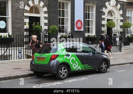 LONDON, Großbritannien - 6. JULI 2016: Menschen laufen durch Zipcar Fahrzeug in London, UK. Zipcar ist eine US-amerikanische Car-sharing-Unternehmen. Es ist ein Teil von Avis Budget Group. Stockfoto