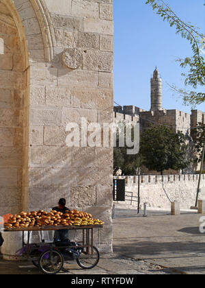 JERUSALEM - Oktober 2011: Ein junger Verkäufer sitzt am Jaffa Tor Eingang in die ummauerte Altstadt von Jerusalem, Verkauf von frischen Backwaren. Stockfoto