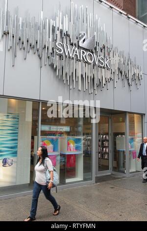 NEW YORK, USA - Juli 1, 2013: Leute gehen von Swarovski Stores in New York. Marke Swarovski besteht seit 1895 und hat 24,841 Mitarbeiter (Dez. 2009). Stockfoto
