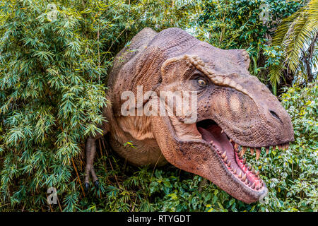 ORLANDO, Florida, USA - Dezember, 2018: Dinosaurier zwischen den Büschen mit seinen Mund, seine Zähne zeigt an Jurassic Park, Universal Studios oder Stockfoto