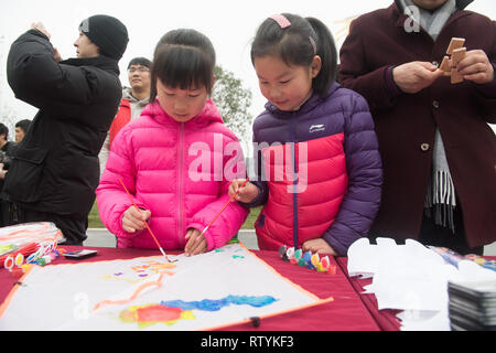 Huzhou, der chinesischen Provinz Zhejiang. 3 Mär, 2019. Kinder arbeiten auf einem Gemälde an gucheng Dorf Daochang Township in Huzhou City, East China Zhejiang Provinz, 3. März 2019. Eine Kultur und Tourismus Fall wurde an gucheng Dorf statt und zieht viele Touristen Volkskultur zu erleben. Credit: Weng Xinyang/Xinhua/Alamy leben Nachrichten Stockfoto