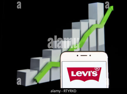 Hong Kong. 10 Feb, 2019. American Clothing Marke Levi's Logo ist auf ein Android mobile Gerät mit einem Aufstieg Wachstumsdiagramm im Hintergrund zu sehen. Credit: Budrul Chukrut/SOPA Images/ZUMA Draht/Alamy leben Nachrichten Stockfoto