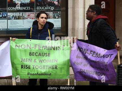 Zwei Demonstranten gesehen Holding Banner während eines Protestes gegen den Feminismus. Anti feministischer Protest außerhalb der Central Hall Westminster, wo die Care International der Internationale Frauentag feiern. Stockfoto