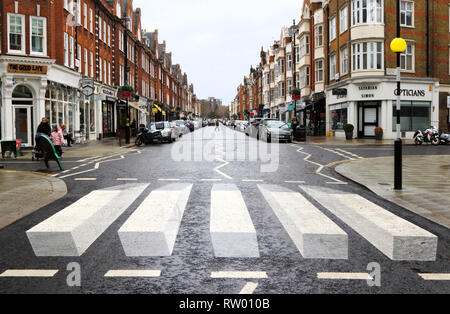 Großbritanniens erste '3D' Zebrastreifen wurde am St John's Wood High Street als Teil einer 12-Tage-Testversion gemalt. Die Stadtverwaltung von Westminster sind Erprobung nach Verkehrssicherheit Bedenken von Anwohnern und einer örtlichen Schule. Die raffiniert bemalte Streifen erwecken den Eindruck, dass sich die Fahrzeuge über sind über eine Rampe in den 3D-Effekt zu Laufwerk funktioniert entweder aus Richtung. Stockfoto