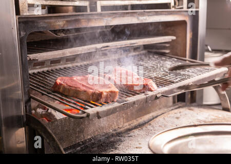 Lebensmittel, Essen und leckere Konzept - Röstung ein Steak von Pferdefleisch auf Grill Stockfoto