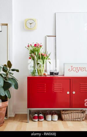 Lebendige innere szene bunte Blumen und roten Schließfach im Apartment Atmosphäre Stockfoto