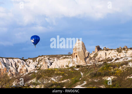Göreme, Provinz Nevsehir, Türkei: ein Heißluftballon fliegt über Fairy Chimney Felsformationen in der historischen Region Kappadokien. Stockfoto