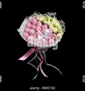 Schöne zarter Bouquet aus Erdbeeren in Schokolade rosa und weißen Rosen steht in einem Glas Vase auf einem schwarzen Hintergrund Stockfoto