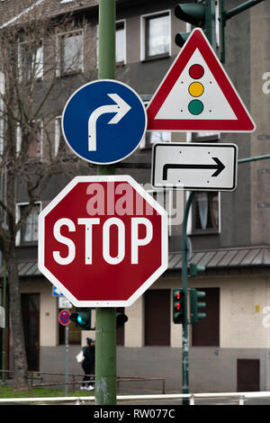 Verkehrszeichen für Richtung und Stop, zusammen mit Fußgängerampel im Hintergrund Stockfoto