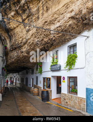 Eine Straße unter einen massiven Felsen Felswand in Setenil de las Bodegas, einer Stadt in der Provinz Cádiz, Andalusien, Spanien gebaut Stockfoto