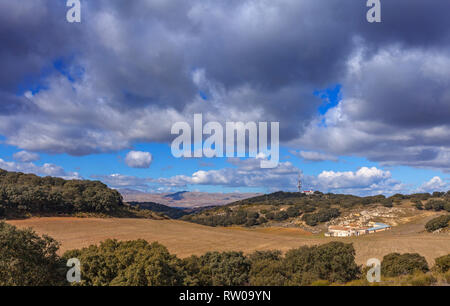 Eine Kommunikation mast überragt ein Ausbreiten, aber verlassenen Bauernhaus oder Casa de Campo, mit gepflügten Feldern vor. Provinz Granada, Spanien Stockfoto