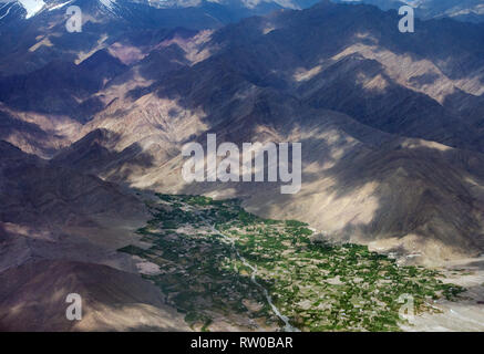 Berg Tal von der Höhe der Ebene, grüne Felder entlang des Flusses, Licht und Schatten auf den Pisten, den Himalaya. Stockfoto