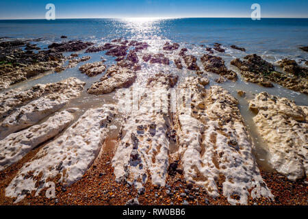 Seewasser fließt über weiße Kreidefelsen an der englischen Südküste Stockfoto