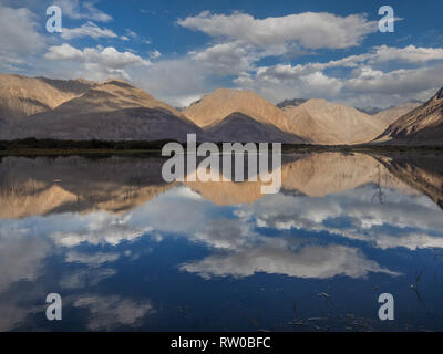 Reflexion der Berge und Wolken in einem blauen See, Nubra Tal, Jammu und Kaschmir, Indien. Stockfoto