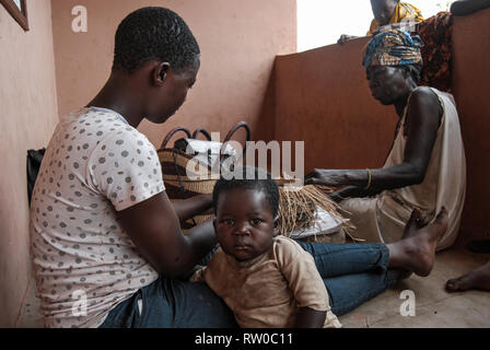 Ein Foto eines ghanaischen Frau mit einem kleinen Kind und ihre Mutter, die berühmte Bolgatanga markt Körbe aus Elefantengras (veta Vera) Stockfoto